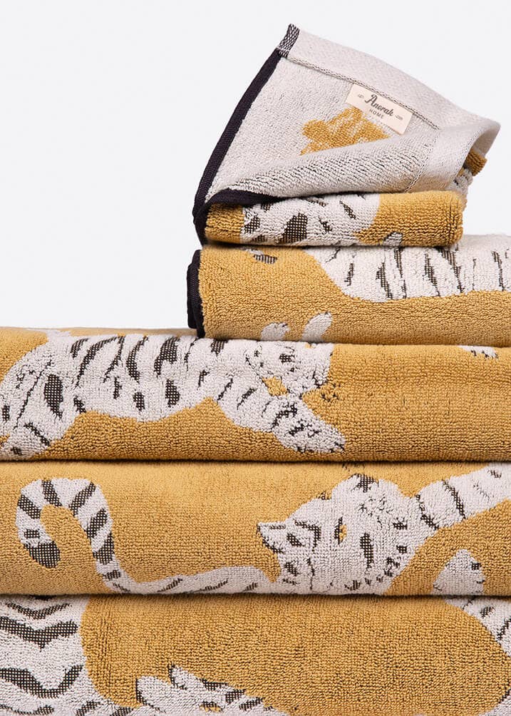 Stack of folded towels with tiger patterns on a white background. Perfect gift for animal lover.