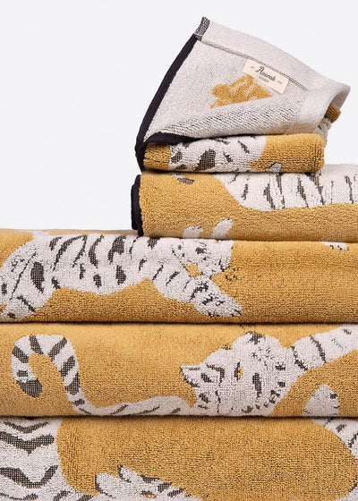 Stack of folded towels with tiger patterns on a white background. Perfect gift for animal lover.