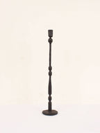 Single tall tall iron candlestick on white studio background. Eliot candlestick handcrafted in India using traditional techniques.