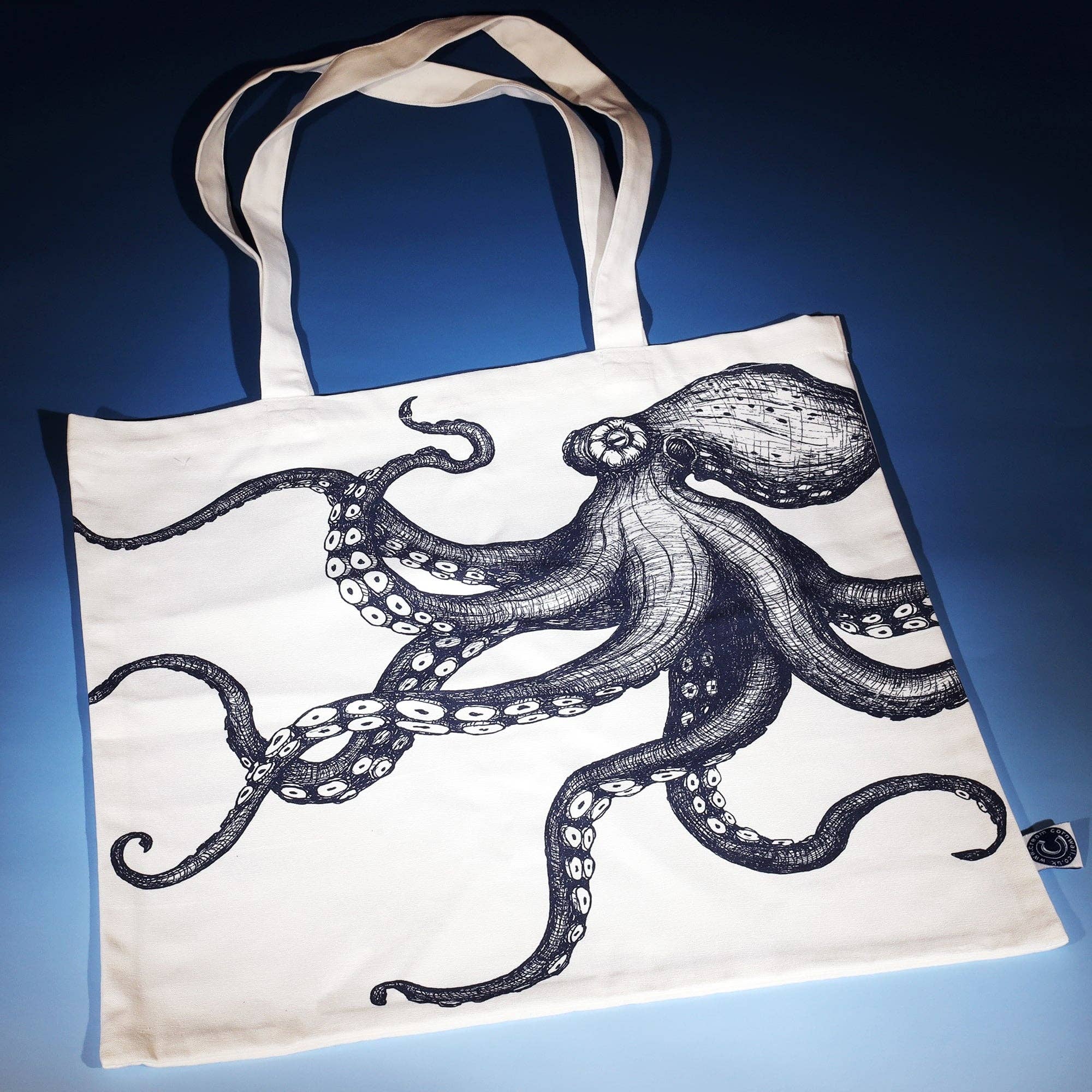 Octopus tote bag flat on blue surface.