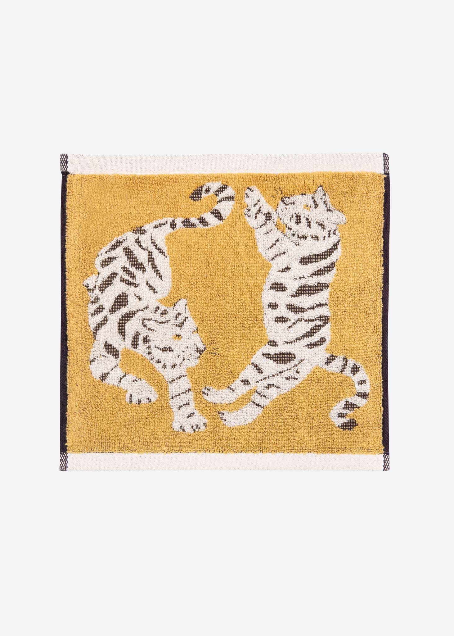 Face cloth with two white tigers on a mustard yellow background. 