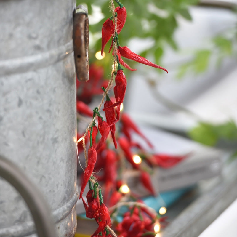 Chilli lights shown in outdoor setting, greenery in background.