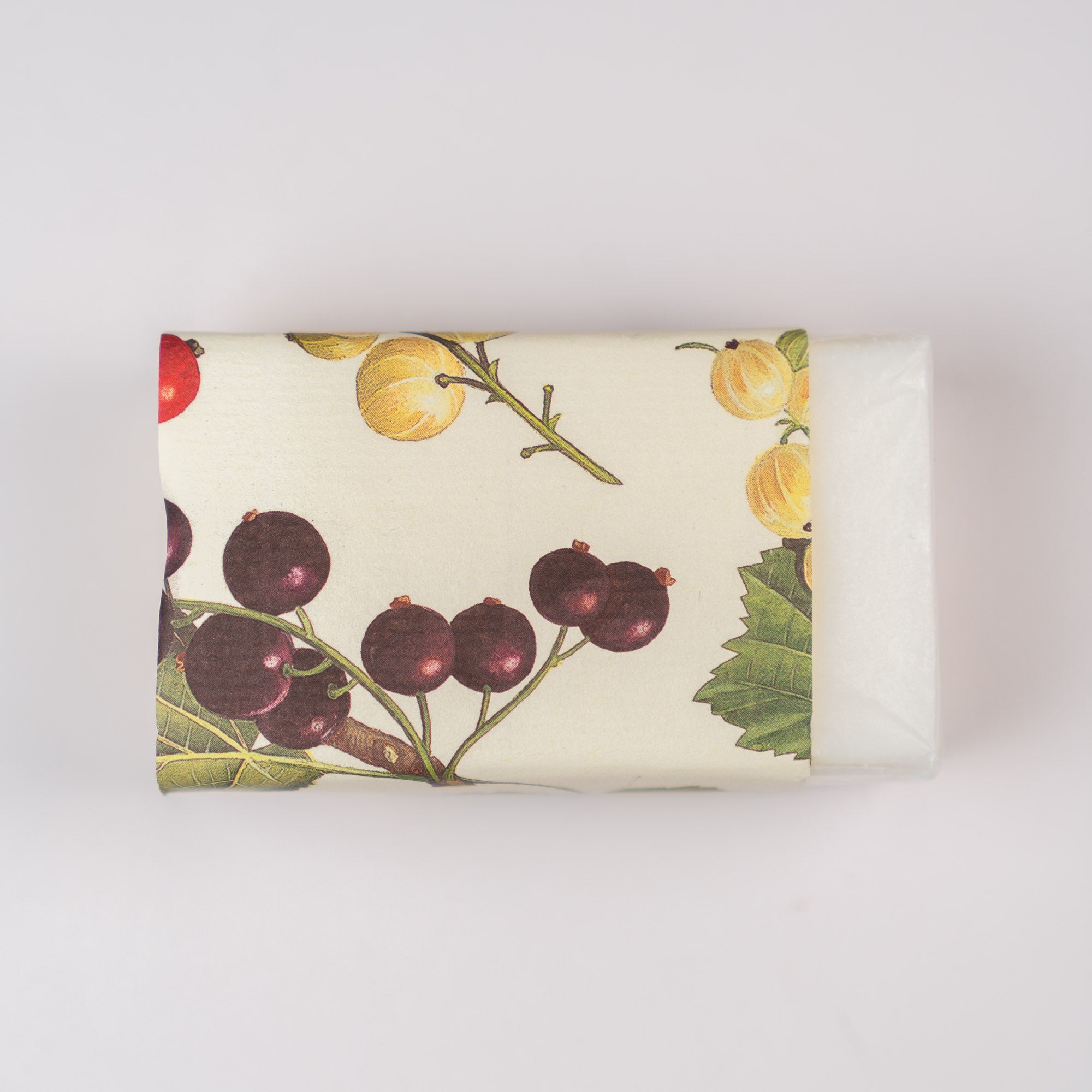 Bar of soap with botanical design on a white background some soap is showing from underneath the wrapper.