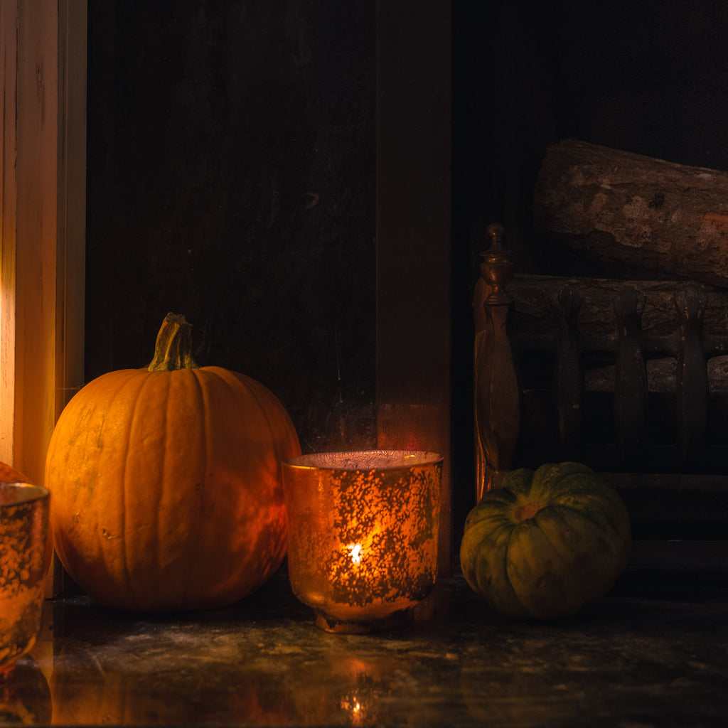 Autumn scene with copper tealight holder next to a pumpkin and small green gourd. Copper tealight - cosy warm and inviting.