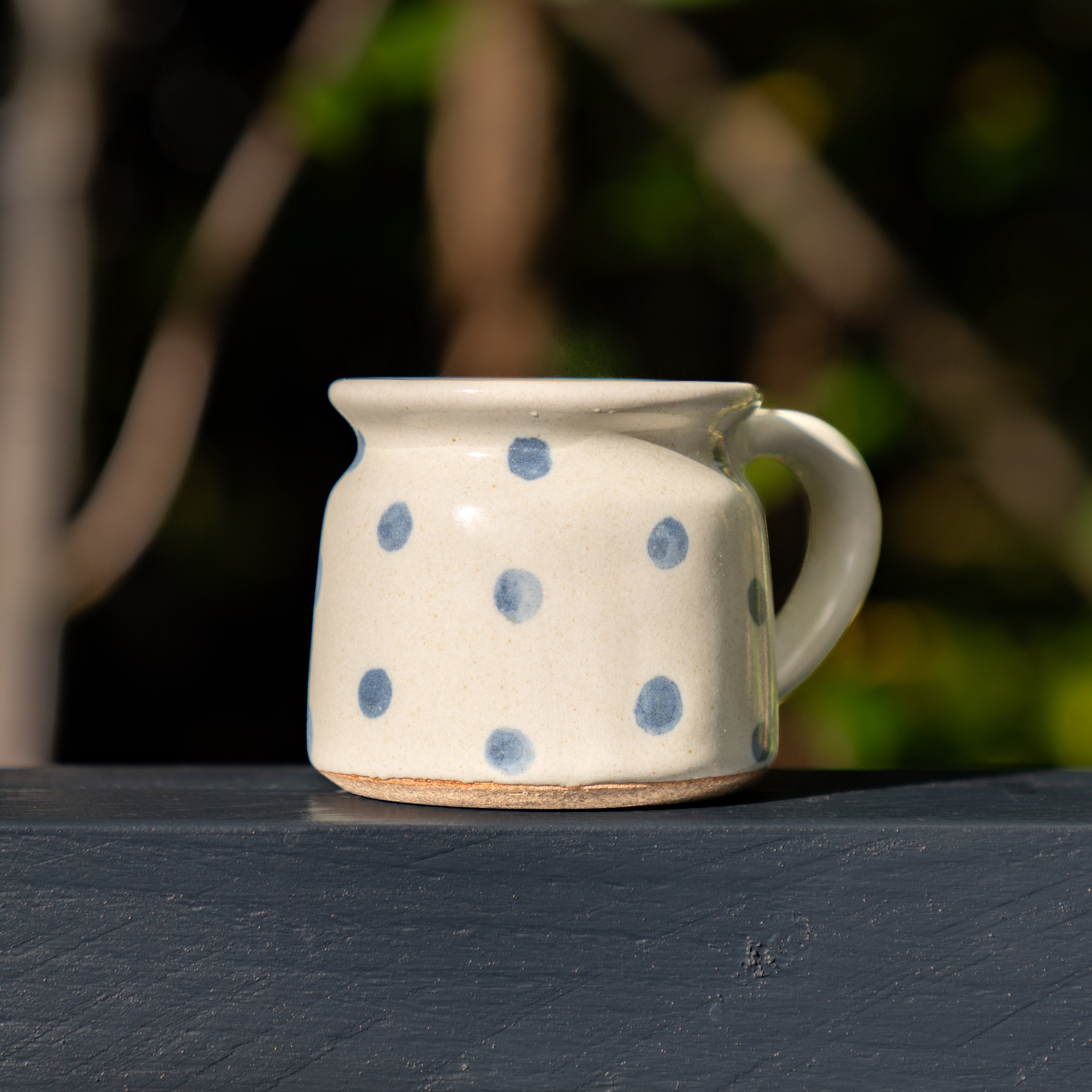 Outdoor shot, close up of polka dot blue spot mug on dark navy surface.
Fairtrade mugs from India make a great gift.