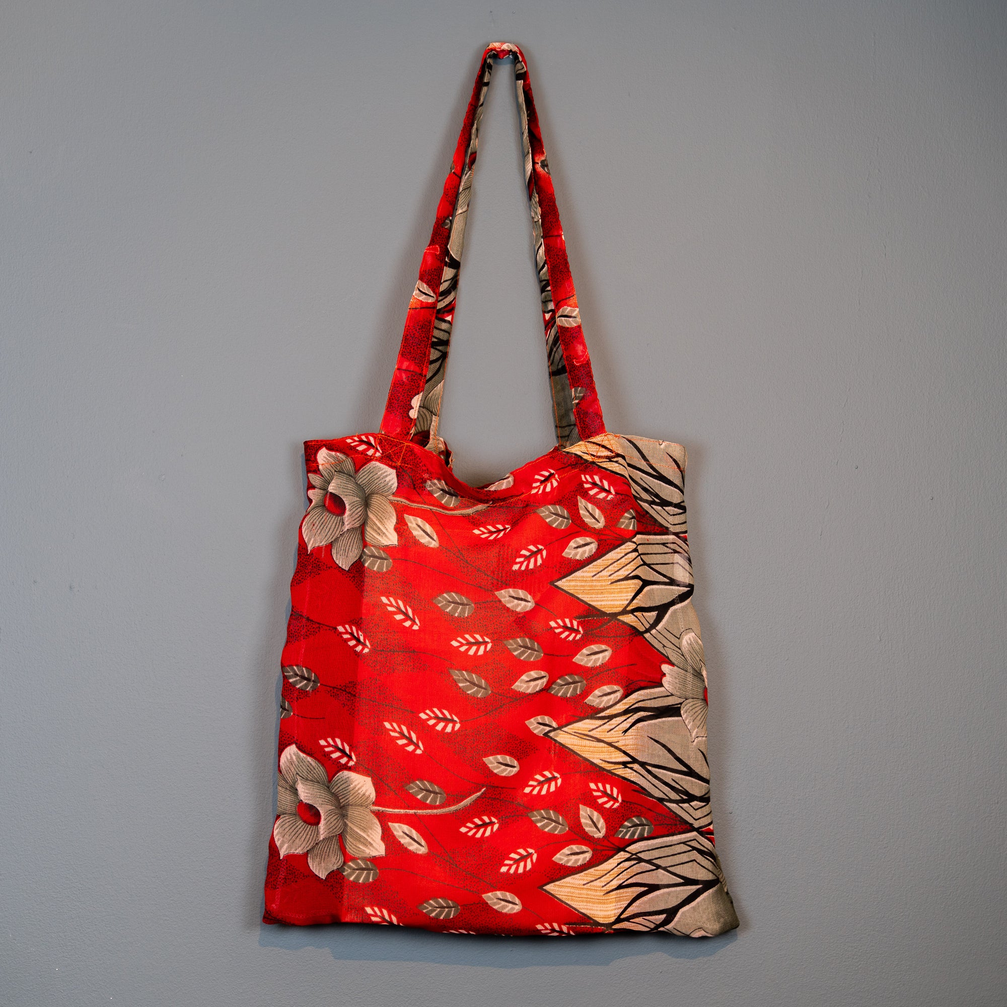 Fairtrade shopping bag in red and cream floral pattern.