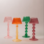 Four colourful  lamp-style glass tealight holder on a plain background