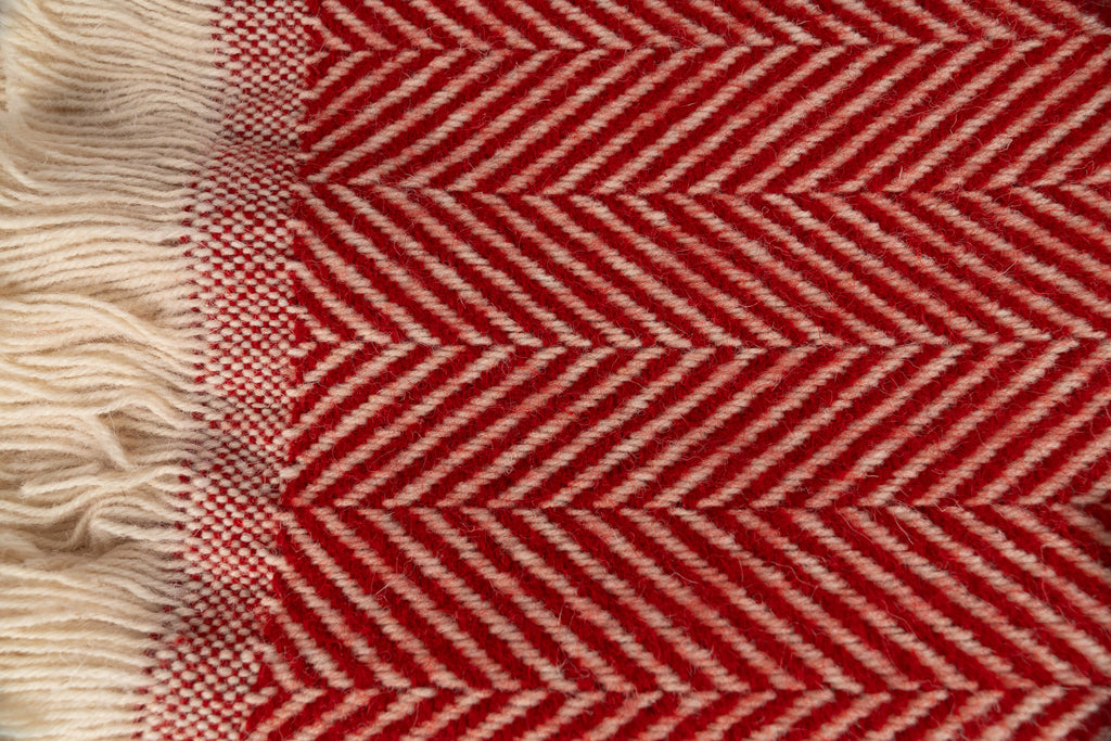 Close up of Tweedmill Textiles Poppy coloured blanket with cream firinge. 100% recycled wool.
