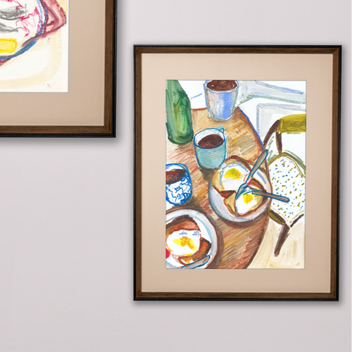 Framed artwork of a breakfast scene with eggs and toast on a table.
