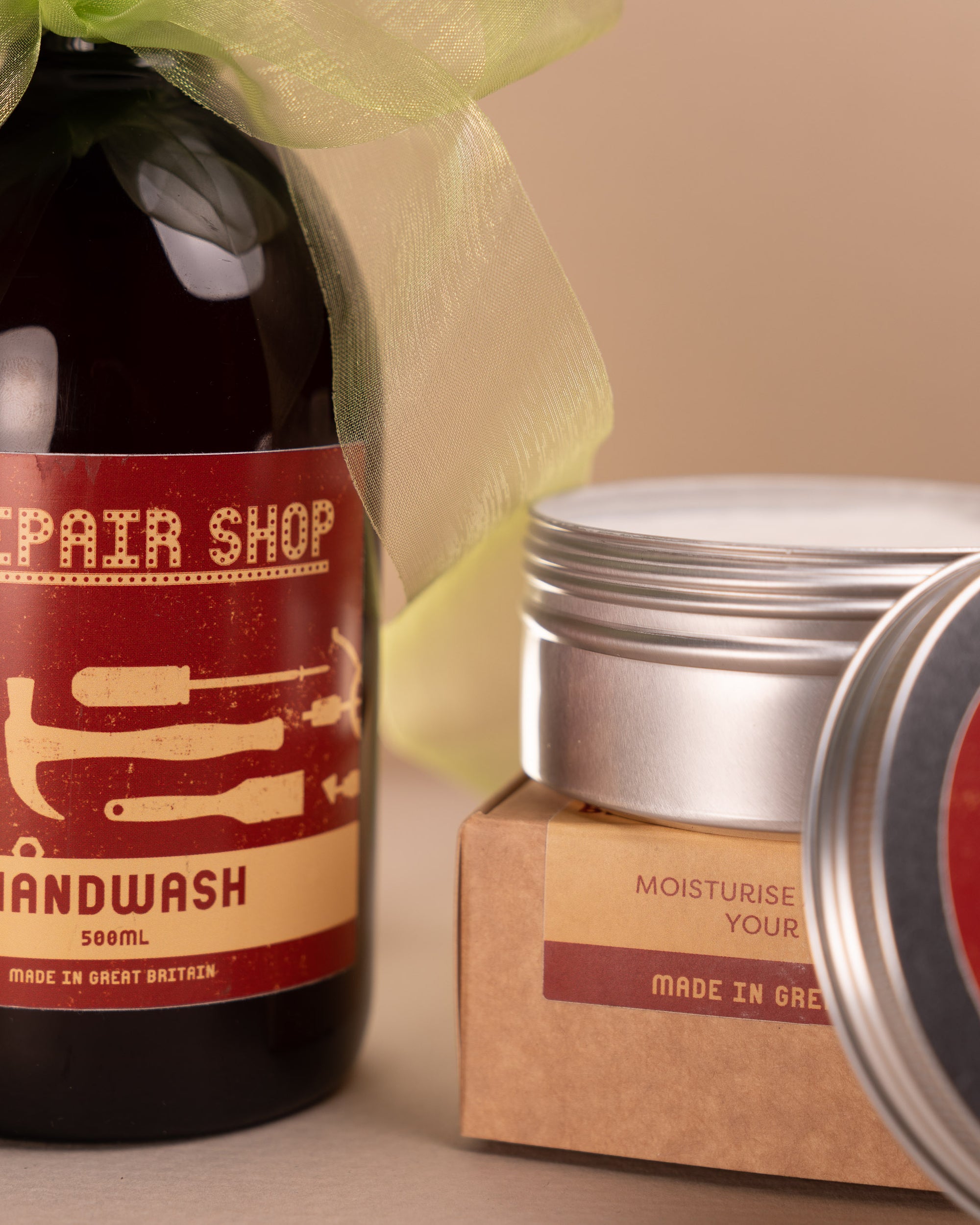 A close up shot of The Repair Shop handwash and Hand Cream. An organza pale green ribbon is tied around the handwash, sold as The Repair Shop Gift set bundle.