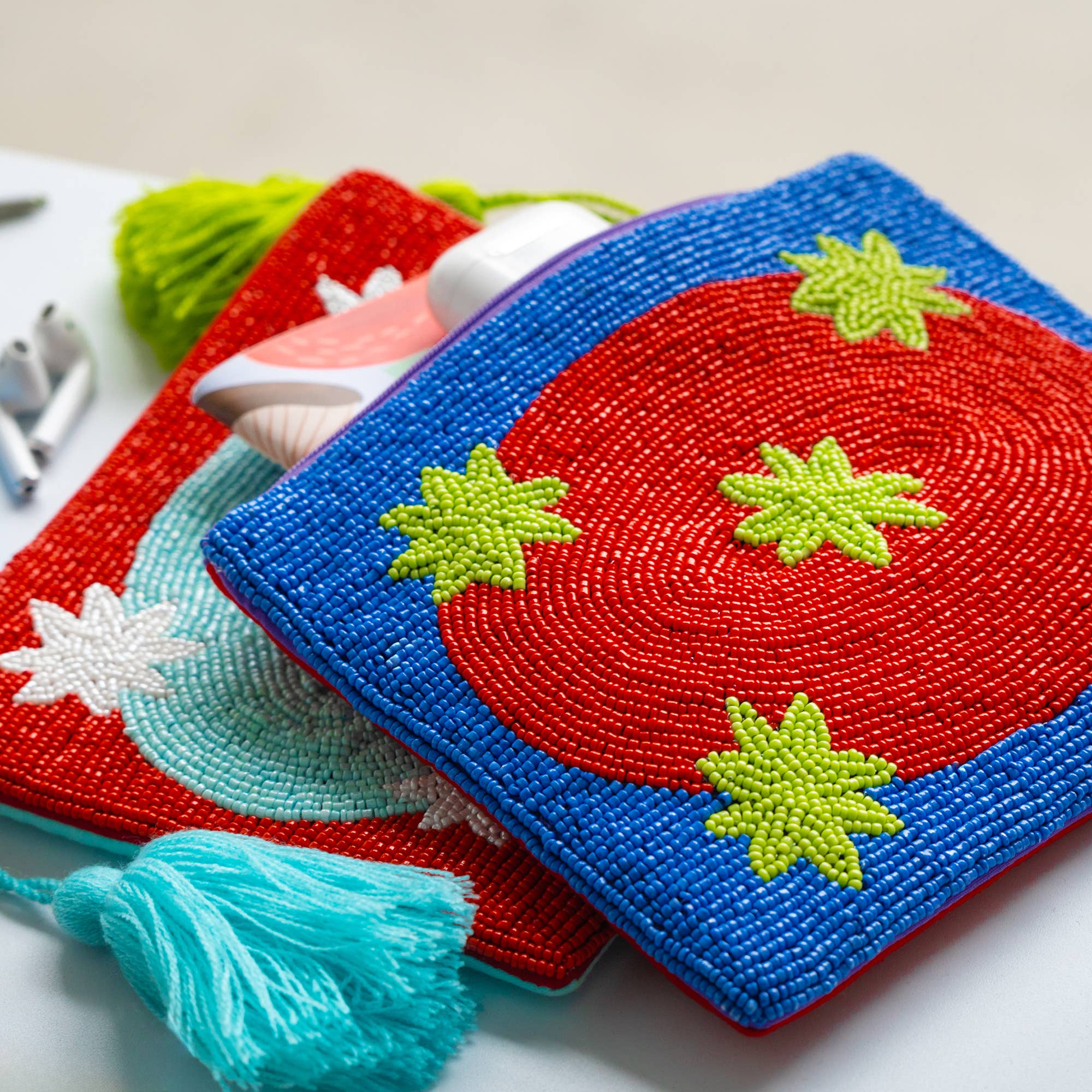 Colorful blue beaded clutch bag/pouch with green star patterns on a a red oval shape.