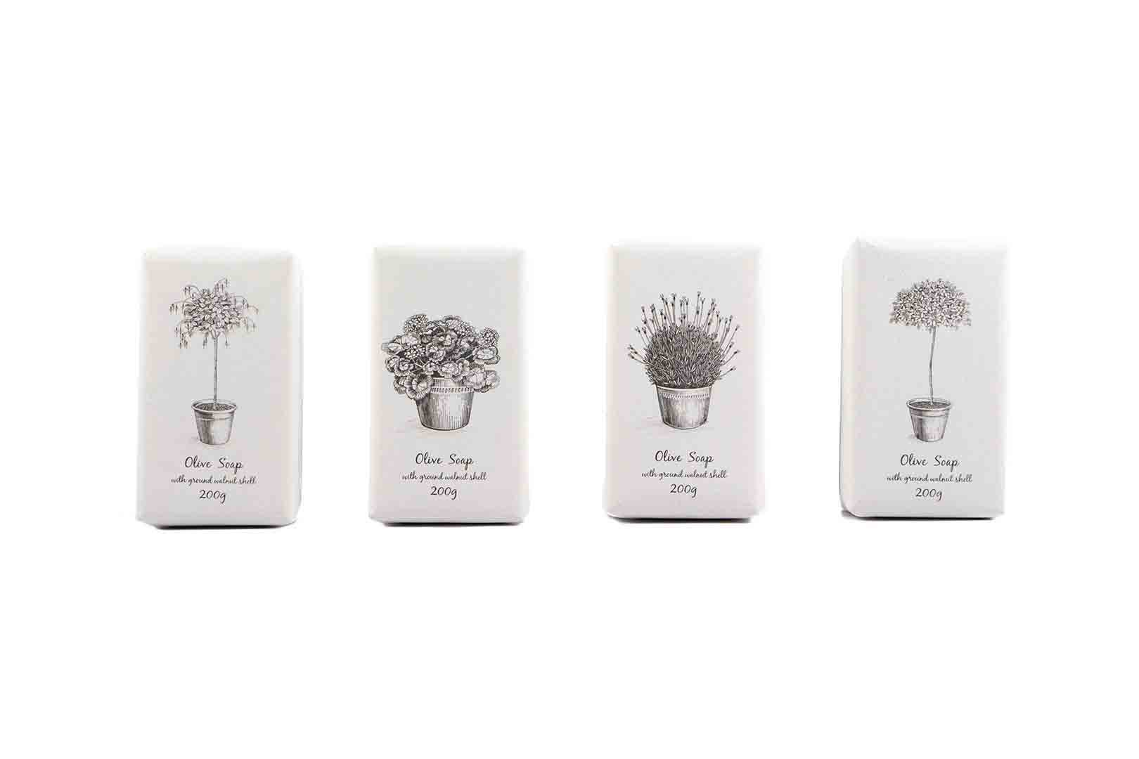 Four wrapped soaps showing variety of botanical illustrations on wrappers. Studio shot white background.