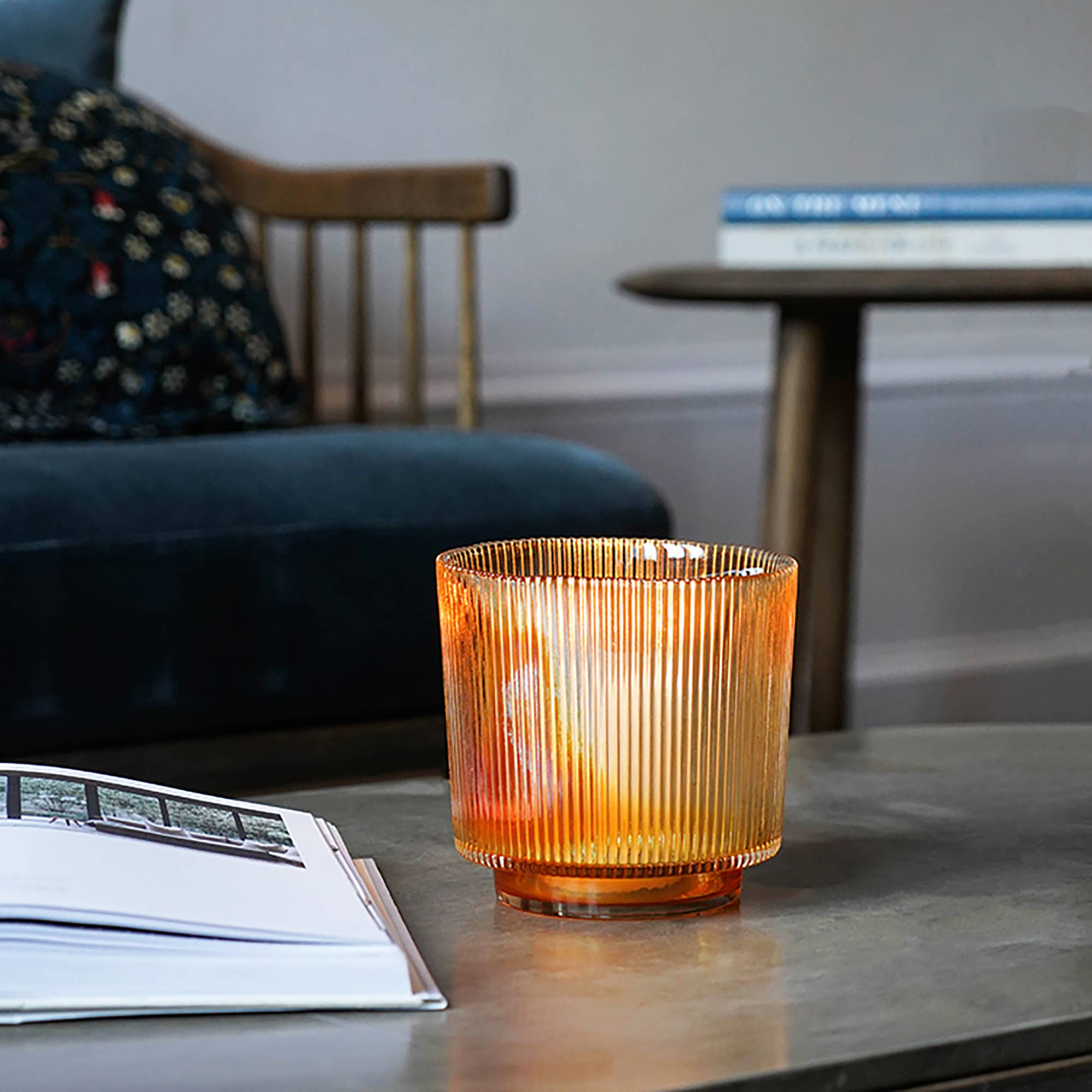 Interior shot of Amber glass holder on coffee table in living space. Book on table - Amber glass is glowing.