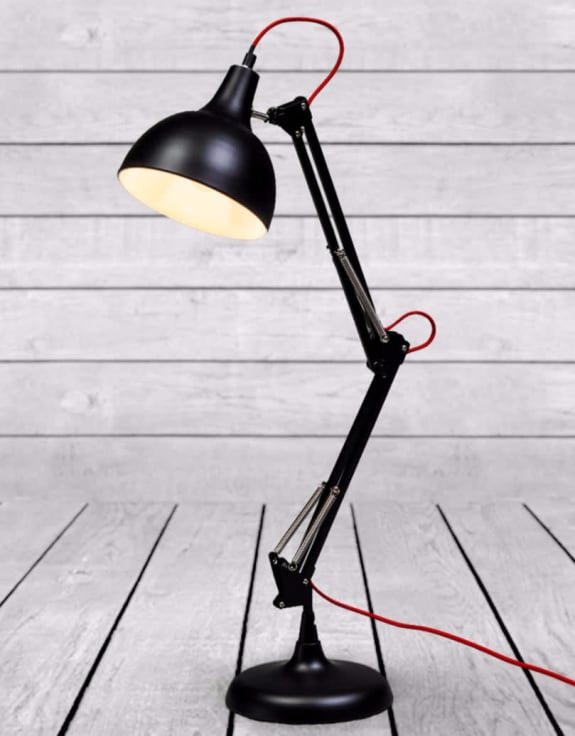 Black adjustable desk lamp on a light wooden floor