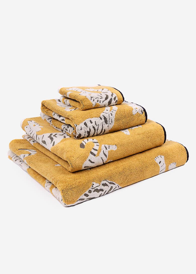 Set of ochre towels with tiger pattern on a white background. 

