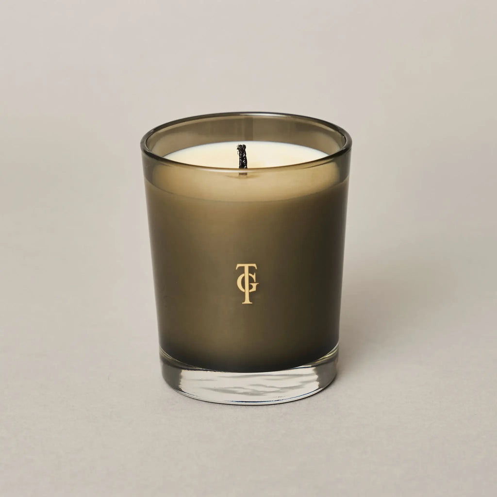 True Grace Portobello Oud Classic candle .Logo shown in gold on smoked glass holder - candle is unlit.