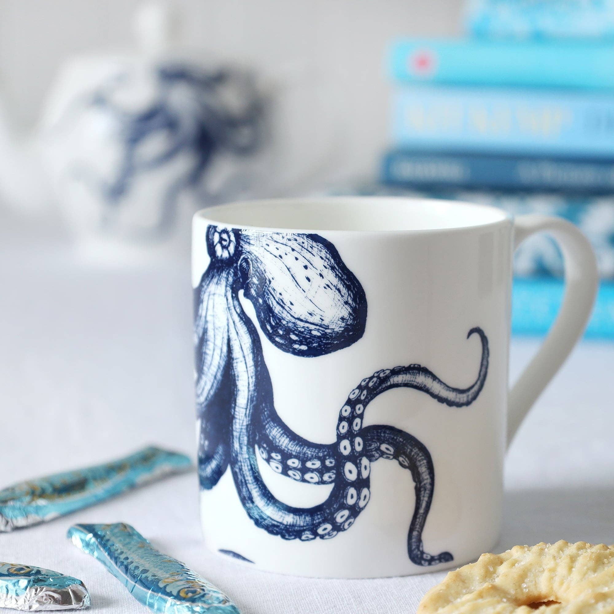 Close up of Octopus mug on a table setting with some wrapped chocolates.